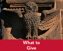 A statue of an owl on a building. Links to What to Give